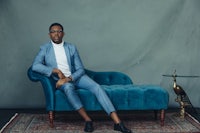 a man in a blue suit sitting on a blue couch